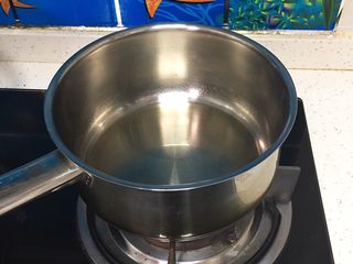 7、咖啡玉枕蛋糕,玉米油中加入盐在煤气灶上加热，不要沸腾，倒入咖啡融化，再倒入牛奶翻拌均匀。