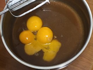 8、咖啡玉枕蛋糕,倒入蛋黄，用打蛋器低速搅拌均匀。