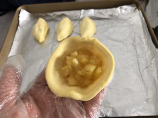 5、酥甜菠萝酥,烤盘铺锡纸刷油，蛋挞皮解冻去掉外壳铝箔，包上菠萝馅
