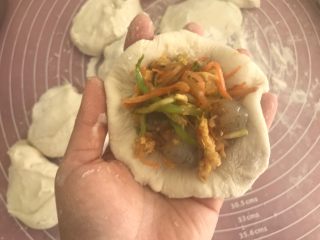 12、角瓜鲜虾包,擀成中间厚四周薄的包子皮后加入适量馅料。