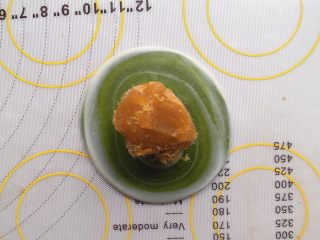 17、抹茶酥,拍扁后 将酥皮翻个面,用擀面杖 稍微擀开一点,然后将莲蓉肉松馅放在中间