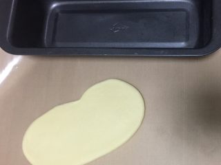 8、蔓越莓椰蓉千层吐司,取出一个面团，擀成长舌状，宽度和吐司模具要一致。