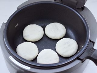 17、紫甘蓝鸡肉馅饼,炒菜机里刷上一层薄薄的油,把做好的包子摁扁放入锅中。