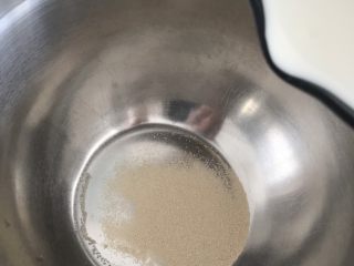 3、无需打发，无需泡打粉的松饼,酵母放入盆里，把加热的牛奶倒入盆中，用蛋抽给搅拌均匀。