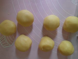 9、蛋黄酥黄油版,将松弛好的油酥材料也分成七等份盖上保鲜膜备用