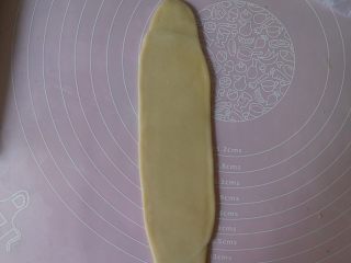 17、蛋黄酥黄油版,将松弛好的面卷取一个出来用手先拍扁然后用擀面杖再次擀平