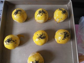 24、蛋黄酥黄油版,(烤箱预热170度上下火)包好的蛋黄酥 我们在表面刷上蛋黄液在撒上芝麻。