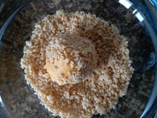 11、香糯南瓜饼,包好豆沙的南瓜球放进芝麻碗内，沾上芝麻