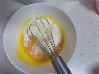 3、奶香南瓜手指饼干,先把蛋黄搅拌均匀，再加入奶粉搅拌均匀