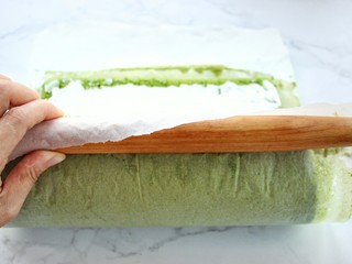 18、抹茶奶油蛋糕卷,用擀面杖反卷油纸带动蛋糕片卷起来，即成蛋糕卷，放进冰箱冷藏两个小时以上