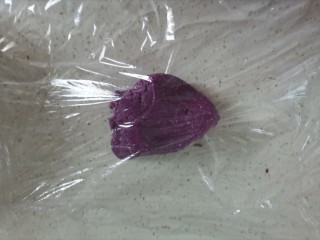 10、紫薯椰蓉饼干,取一半面团放在保鲜膜上，上面也盖上保鲜膜