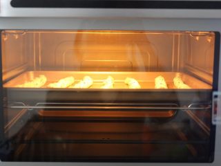 11、黑芝麻椰蓉面包棒,将搓好的螺纹条放入烤箱，用手机调好发酵功能，发至2倍大即可