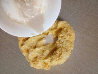 4、超软白米粥吐司,取15克水将酵母融化倒在面团上,这时揉面会有点黏经过揉、摔、撮等动作面团在上手会慢慢的变得没那么黏了。