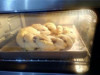 19、椰蓉花环面包,在表面轻刷蛋液，不刷也可以。 放入充分预热好的烤箱。烤箱中层，上下火180度，20～25分钟，根据所编花环的厚度调整烘烤时间，上色满意时盖锡