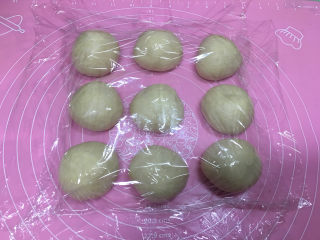5、淡奶油辫子面包,将发好的面团取出，进行排气，然后分成9份，揉圆后盖保鲜膜醒发10分钟。