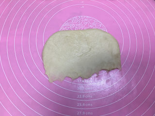 6、淡奶油辫子面包,醒发完毕，取一个面团擀开，然后翻面横着，将底部压薄。