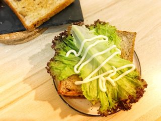 12、巨无霸早餐三明治????,盖上面包片之后摆上剩下的两片生菜,挤上沙拉酱。