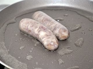 11、香肠吐司披萨,现在来准备披萨馅料,平底锅中倒入少量油,小火煎香肠,我用的珍妮珍馐的秘制原味纯肉香肠,不含淀粉,小朋友很喜欢。