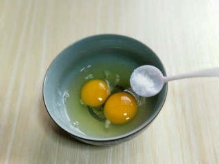 2、#感恩节食谱#营养早餐～鲜虾吐司卷,将鸡蛋敲再碗里，加入少许盐。