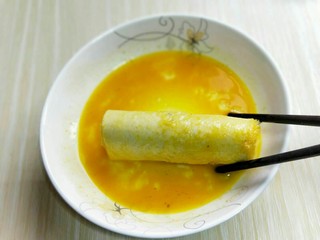 15、#感恩节食谱#营养早餐～鲜虾吐司卷,将卷好虾肉的吐司卷放入蛋液中，沾满蛋液，依次做完。
