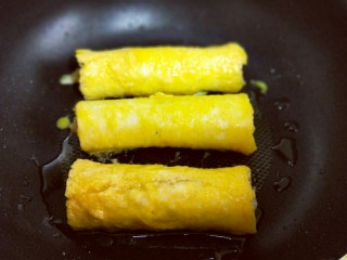 16、#感恩节食谱#营养早餐～鲜虾吐司卷,沾满蛋液的鲜虾吐司卷，放入平底锅中，刷上少许玉米油。