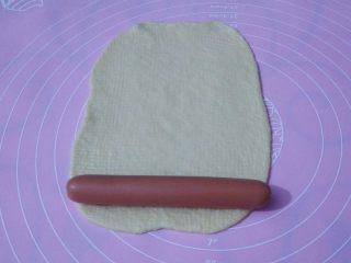 7、香葱芝士面包,面皮放上火腿肠，从下往上卷。