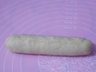 8、香葱芝士面包,卷到顶部，把收口处捏紧，两头捏紧，不要让火腿肠露出来。