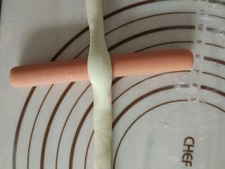 6、热狗面包,揉好的面团对半放在火腿肠中间