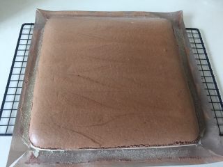 12、可可旋风瑞士卷(后蛋法),摔过以后及时从金盘里把蛋糕片连同油布拎出来,移到晾网架上撕开四周的油布,这样更有利于散去热气。