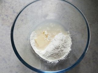 1、中式点心~玫瑰酥,水油皮的用料，全部放在容器中进行混合，水油皮一定要把面揉透柔滋润。