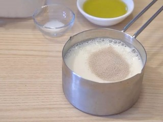 4、日式红豆包,面包:牛奶里放入干酵母,搅拌均匀,静置10分钟左右