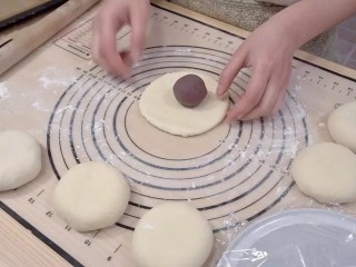 10、日式红豆包,取一个松弛好的面团,擀成圆形,放入一个豆沙球