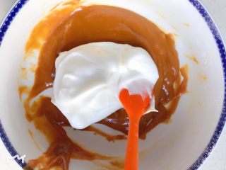 6、焦糖海盐戚风蛋糕,取1/3蛋白与蛋黄糊,翻拌混合均匀。焦糖蛋黄糊较普通戚风蛋黄糊会浓一些,混合时一定要翻拌,注意手法