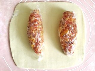 7、千层酥皮香肠卷,用擀面杖均匀地擀开面皮，面皮的厚度为3mm，大小比两个肉馅儿的大小，稍微大一圈，可以用肉馅儿比量一下大小