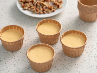 8、努力吧！碧根果奶油蛋糕,把面糊挤入纸杯中。