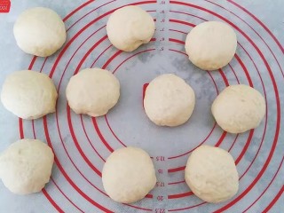 4、果酱奶酥排包,然后将面团取出挤压排气后，再分成均匀的10个小面团滚圆，盖保鲜膜醒发15分钟左右；