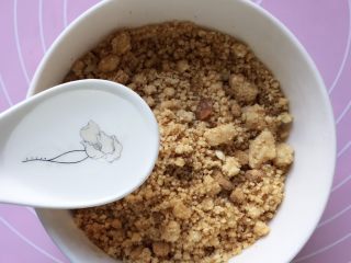 6、香煎花生南瓜饼,将红糖加入花生碎的碗里混合,加入一勺清水