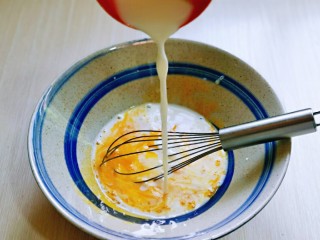 3、蒸蔓越莓蛋糕～电饭煲版,先做蛋黄糊，蛋黄用手动打蛋器打散，加入牛奶继续打均匀至看不到牛奶。