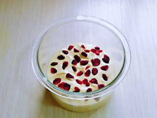 15、蒸蔓越莓蛋糕～电饭煲版,再将拌好的蛋糕糊倒入美的BB煲的玻璃内胆中，再撒上蔓越莓干，如图。