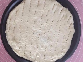 6、培根时蔬披萨,放在披萨盘里,用叉子在表面叉一些孔,室温发酵30分钟后175度预热5分钟,烤10分钟。