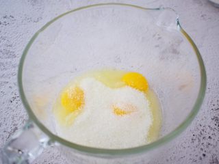 3、可露丽,鸡蛋、蛋黄、白糖放入盆中，用手动打蛋器搅拌至白糖融化