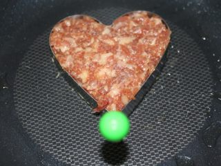 10、爱心蛋汉堡,先放模具，然后舀进肉末，铺平，开煎