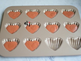 9、红丝绒玛德琳蛋糕,加盖保鲜膜，放冰箱冷藏1个小时，取出来，放置十分钟，翻拌一下，装裱花袋，裱花袋剪一个小口，挤入模具中