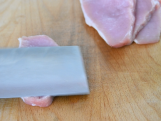 1、在家轻松炸猪排,色泽金黄有食欲!,先将猪里脊切成厚片,用刀拍一下,把肉片拍大