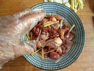 6、歌乐山辣子鸡,将切好的鸡块放入碗中,加入盐 ,鸡精,料酒 ,酱油 ,姜片,葱丝,抓拌均匀,腌制15-20分钟。