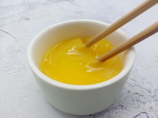 5、面包糠炸虾,准备一个鸡蛋、加少许的细盐。用筷子把鸡蛋打散备用。