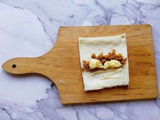 6、肉松吐司卷,挤入蛋黄酱，放入肉松和奶酪，再卷起来