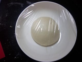 3、奶香蜜豆包,.面团在操作台上，整理光滑。容器底部抹油，面团置于容器盖保鲜膜进行一发。