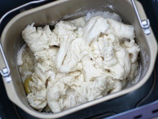 4、酒酿排包,将发酵好的中种面团撕成小块也放入面包桶内