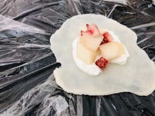 12、百味糯米糍,揪一拖糯米糕，放在两张保鲜膜中间，擀成薄皮，中间可以略厚，边可以很薄，放上奶油和桃子。